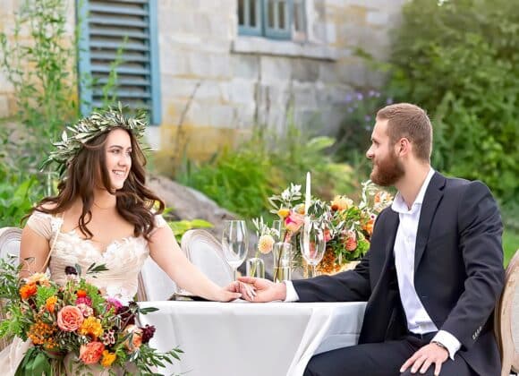 Toscaanse bruiloft met man en vrouw die elkaars handen vasthouden aan tafel
