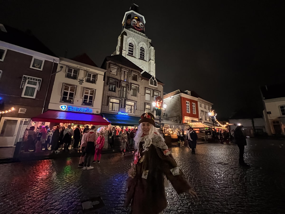 Esmée voor de Peperbus in Bergen op Zoom in Vastenavend kleding: een bontjas, gordijn, rode zakdoek, witte pruik en hoed